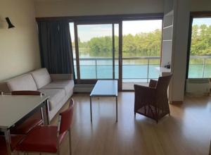 a living room with a couch and a table and chairs at Studio Laguna Beach Knokke-Heist in Knokke-Heist