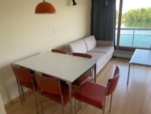 a living room with a couch and a table and chairs at Studio Laguna Beach Knokke-Heist in Knokke-Heist