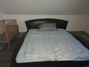1 cama con cabecero negro en un dormitorio en Hóvirág Vendégház en Balatonakali