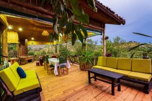 porche con sofá, mesa y sillas en Ruhondo Island Retreat, en Ruhondo