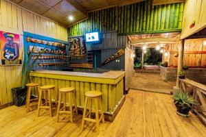 un bar con taburetes en una habitación con suelo de madera en Ruhondo Island Retreat en Ruhondo