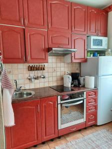 a kitchen with red cabinets and a white refrigerator at Aalto 17 in Haapsalu