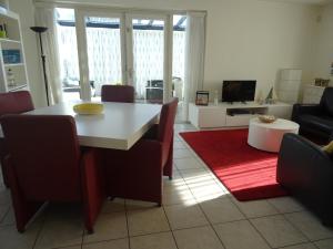 een woonkamer met een tafel en stoelen en een bank bij Kustverhuur, Park Scheldeveste, Schelde 220 in Breskens