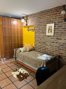 1 dormitorio con cama y pared de ladrillo en Departamento Barrio Gamma en Neuquén