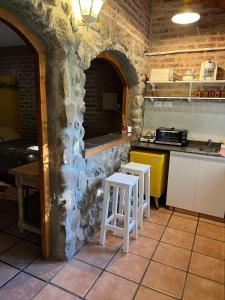 una cocina con 2 taburetes en una pared de piedra en Departamento Barrio Gamma en Neuquén