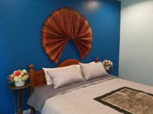 a blue bedroom with a bed with a large headboard at นอนในสวน รีสอร์ท in Bangkok