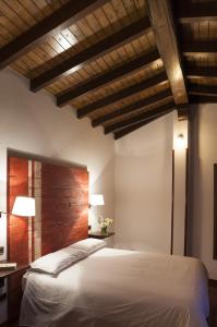 a bedroom with a white bed and a wooden ceiling at Hotel Gastronómico Cabo Vidío in Oviñana