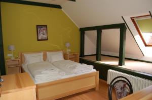 a bed in a room with a green wall at Penzion Markus in Frymburk