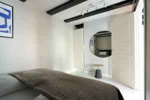 um quarto com uma cama e um espelho em Unique 2 Bedroom Duplex w Exposed Beams in CPH City em Copenhague