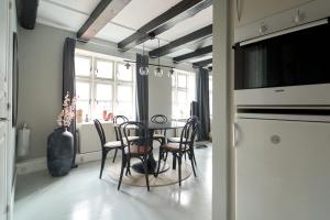 ein Esszimmer mit einem Tisch und Stühlen in der Unterkunft Unique 2 Bedroom Duplex w Exposed Beams in CPH City in Kopenhagen
