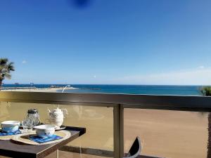 - une table avec de la nourriture et une vue sur l'océan dans l'établissement Rêve de plage - Confortable appt pour 2, à Canet