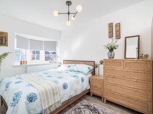 - une chambre avec un lit, une commode et un miroir dans l'établissement Pass the Keys Stylish Family Friendly 3 Bed Home in Borehamwood, à Borehamwood