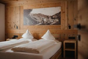 two beds in a room with a picture on the wall at Gourmet Hotel Gran Ander in Badia