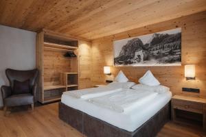 a bedroom with a large bed and a chair at Gourmet Hotel Gran Ander in Badia