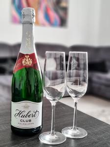 butelkę wina i dwa kieliszki wina na stole w obiekcie Spacious apartment near hockey and football arena w mieście Trnávka
