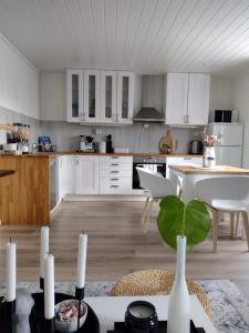 una cocina con armarios blancos y una mesa con una planta en Light home apartment Alesund with free parking, en Ålesund
