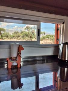 een raam in een trein met uitzicht op een veld bij Tampu, the Container House in Cafayate