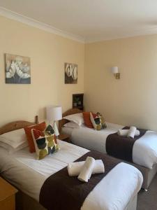 ein Hotelzimmer mit 3 Betten und Kissen in der Unterkunft The Dickens Bar & Inn in Scarborough