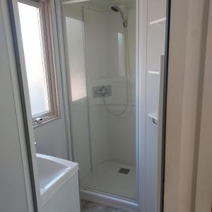 a bathroom with a shower with a glass door at Camping Onlycamp Le Petit Bocage in Les Essarts