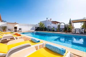 une piscine avec des chaises et une piscine dans l'établissement Villa Estrelícia - Pool - Free wi-fi - New in Booking, à Loulé