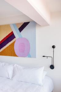 a bedroom with a white bed and a painting on the wall at Good Hotel Guatemala City in Guatemala