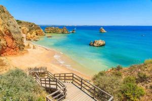 una scala che conduce a una spiaggia con rocce in acqua di SunHome Casas de férias em Portimao a Portimão