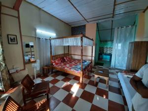 1 dormitorio con cama con dosel y suelo a cuadros en Leela Cottages, en McLeod Ganj