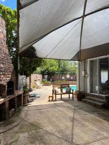 awning over a patio with a bench and a table at Ataria Place in Cradock