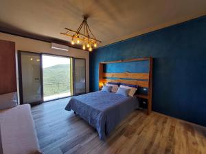 a bedroom with a bed and a blue wall at IL NIDO TRA GLI ULIVI in Lucinasco
