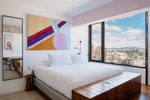 a bedroom with a large bed and a large window at Good Hotel Guatemala City in Guatemala