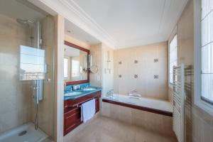 a bathroom with a tub and a sink and a bath tub at Hôtel Pont Royal Paris in Paris