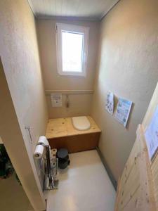 a small bathroom with a toilet and a window at La cabane familiale in Champdieu