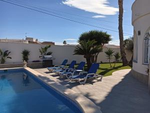 un grupo de sillas sentadas junto a una piscina en Detached Villa With Private Pool Torrevieja, en Torrevieja
