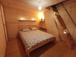 1 dormitorio con 1 cama en una cabaña de madera en Vakantiewoning Henri Vleteren-Ieper 