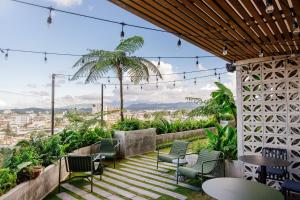 a patio with chairs and tables and a view of the city at Good Hotel Guatemala City in Guatemala