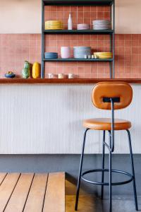 a chair sitting in front of a shelf with dishes at Good Hotel Guatemala City in Guatemala
