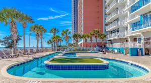 una piscina con palmeras y un edificio en Atlantica 901, en Myrtle Beach