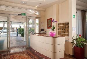 a lobby of a store with a reception counter at Hotel Vela in Milano Marittima +26 photos