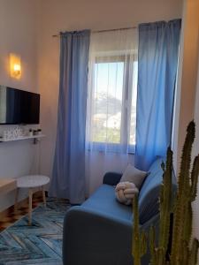 ein Wohnzimmer mit einem blauen Sofa und einem Kaktus in der Unterkunft Apartments M Gregor ideal for relaxing holidays in Baška