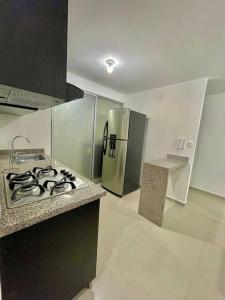 a kitchen with a stove and a stainless steel refrigerator at Divino Apto Cucuta-3 Hab-2 Aires in Cúcuta