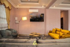 a living room with a yellow couch and a table at GEORGE VEE HOTEL LTD in Kumasi