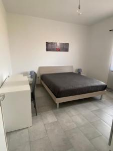 1 dormitorio con cama, mesa y escritorio en Il Sole Verde, en Marrùbiu