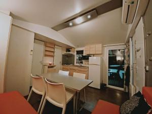 - une cuisine et une salle à manger avec une table et des chaises dans l'établissement Camping la dune blanche, à Camiers
