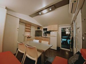 cocina y comedor con mesa y sillas en Camping la dune blanche, en Camiers