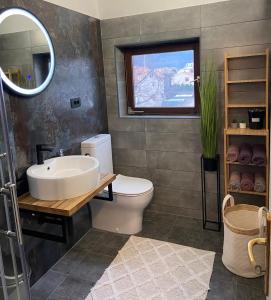 uma casa de banho com um lavatório, um WC e um espelho. em Apartments M GREGOR ideal for relaxing holidays em Baška