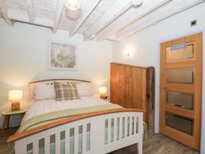 1 dormitorio con cama blanca y armario de madera en The Upside Down House at The Mercers, en Worcester