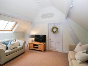 a living room with a couch and a tv at The Upside Down House at The Mercers in Worcester