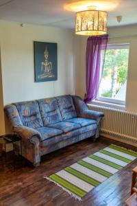 a living room with a blue couch and a window at 3-bedroom condo with indoor fireplace in Nyland