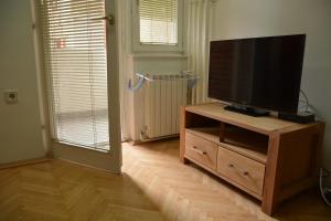 una sala de estar con TV de pantalla plana en un armario de madera en Apartment Kapishtec, en Skopje