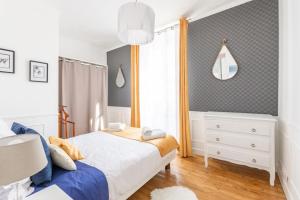sypialnia z białym łóżkiem i oknem w obiekcie L'Escale - de Disney à Paris - Cocon Hyper Centre w mieście Lagny